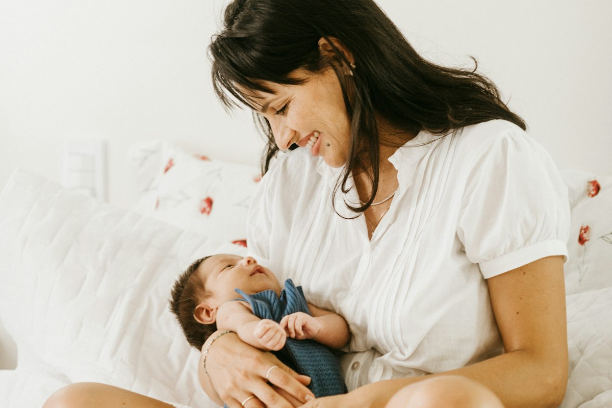 Mãe sorrindo com o bebê no colo