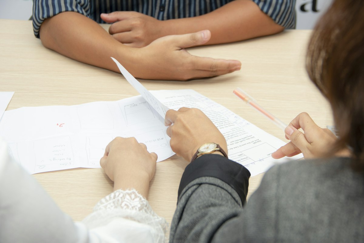 Pessoas conferindo documentos sobre uma mesa